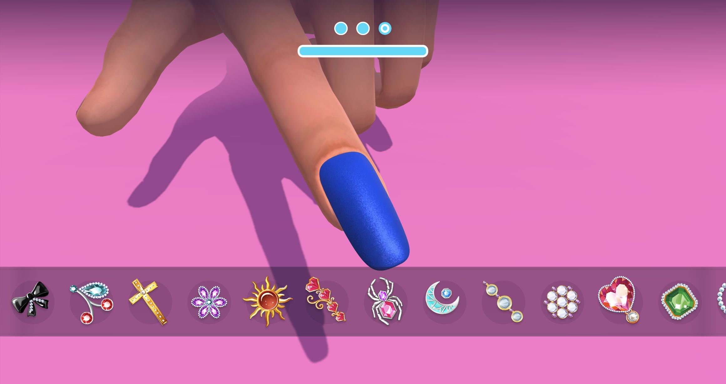 Finished royal-blue nail above a tray of bows, crystals, a cross, flower, sun, spider, moon and gem charms